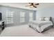 Spacious bedroom with light blue walls, carpet, ceiling fan, and three windows with blinds at 15317 Colonial Park Dr, Huntersville, NC 28078