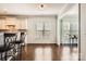 Dining room with wood floors, white walls, white trim, and a view into a bright sunroom with windows at 15317 Colonial Park Dr, Huntersville, NC 28078