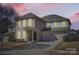Charming two-story home featuring a well-manicured lawn, attached two-car garage, and traditional architectural details at 15317 Colonial Park Dr, Huntersville, NC 28078