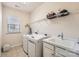 Well-lit laundry room equipped with white washer, dryer, sink, and ample storage space at 15317 Colonial Park Dr, Huntersville, NC 28078