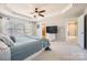 Comfortable main bedroom with tray ceilings, a ceiling fan, many windows, and hardwood floors at 15317 Colonial Park Dr, Huntersville, NC 28078