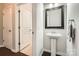 Updated powder room with white pedestal sink, modern framed mirror, brushed nickel fixtures, and dark wood floors at 15317 Colonial Park Dr, Huntersville, NC 28078