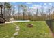 Stepping stone path leads to a cozy fire pit near the pool in the spacious fenced backyard with mature trees at 1770 Cranwell Dr, Mt Ulla, NC 28125