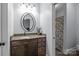 Bathroom vanity with dark wood cabinets, decorative oval mirror and patterned shower curtain at 1770 Cranwell Dr, Mt Ulla, NC 28125