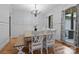 Bright dining room featuring a large window, elegant wainscoting, a rustic table, and a stylish chandelier at 1770 Cranwell Dr, Mt Ulla, NC 28125