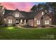 Charming brick and stone home with a well-manicured lawn and inviting front porch, blending elegance with comfort at 1770 Cranwell Dr, Mt Ulla, NC 28125