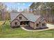 Aerial view of a brick and stone accented home with an expansive yard, complete with mature trees, offering privacy at 1770 Cranwell Dr, Mt Ulla, NC 28125