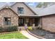 Charming stone and brick home featuring a cozy front porch with rocking chairs and manicured landscaping at 1770 Cranwell Dr, Mt Ulla, NC 28125