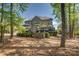 Large brick home with a deck and outdoor seating area surrounded by trees at 17733 Colleton River Ln, Charlotte, NC 28278