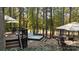 Serene backyard featuring a hot tub, outdoor seating, mature trees, and access to the golf course at 17733 Colleton River Ln, Charlotte, NC 28278