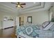 Spacious bedroom with tray ceiling, hardwood floors, paneled accent wall, and natural light from many windows at 17733 Colleton River Ln, Charlotte, NC 28278