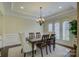 Elegant dining room with a dark wood table, chandelier, and natural light from the windows at 17733 Colleton River Ln, Charlotte, NC 28278