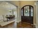 Inviting foyer featuring a grand wooden front door, chandelier, and views into the dining room at 17733 Colleton River Ln, Charlotte, NC 28278