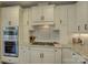 White gourmet kitchen with granite counters, tile backsplash, and stainless steel appliances at 17733 Colleton River Ln, Charlotte, NC 28278