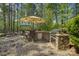 Outdoor kitchen complete with stone counters, stainless grill, bar seating, and a built-in beverage center at 17733 Colleton River Ln, Charlotte, NC 28278