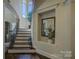 Grand foyer showcasing staircase with dark wood steps, iron railings, a large window, and decorative niches at 17733 Colleton River Ln, Charlotte, NC 28278