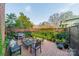 Cozy backyard with brick patio, grill, and lush greenery is ideal for entertaining at 1801 Maryland Ave, Charlotte, NC 28209