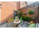 Inviting backyard patio featuring a wooden fence with climbing plants, charming seating, and brick house facade at 1801 Maryland Ave, Charlotte, NC 28209