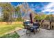 A concrete patio area with an umbrella, chairs, and a wooden deck leading to a covered pool at 1812 Rosewell Dr, Rock Hill, SC 29732