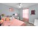 A cozy bedroom is seen, featuring a ceiling fan, pink bedding, vanity and decor at 1812 Rosewell Dr, Rock Hill, SC 29732