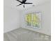 Clean bedroom space with neutral carpet, a ceiling fan, and view of nature at 18512 Square Sail Rd, Cornelius, NC 28031