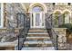 Stone facade, stone steps, and black iron railings lead to the front door of this beautiful home at 18512 Square Sail Rd, Cornelius, NC 28031