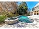 Inviting backyard pool area with a spa, surrounded by beautiful landscaping and a wooden deck at 18512 Square Sail Rd, Cornelius, NC 28031