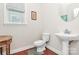 Cozy bathroom with a pedestal sink, toilet, and natural light from the window at 18710 Coverdale Ct, Cornelius, NC 28031