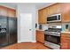 Well-lit kitchen with stainless steel appliances, wood cabinets and a black refrigerator at 18710 Coverdale Ct, Cornelius, NC 28031