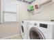 Bright laundry room features a side-by-side washer and dryer and shelving at 18710 Coverdale Ct, Cornelius, NC 28031
