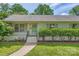 Charming home with lush landscaping, a cozy bench, and a inviting front door with wreath at 2144 Shadyview Dr, Charlotte, NC 28210