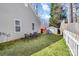 A cozy backyard setup features lawn, chairs, and a bench, next to a white picket fence at 2318 Kestrel Dr, Rock Hill, SC 29732