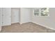 Bedroom with neutral walls, carpet, and large double door closet at 244 N Race St, Statesville, NC 28677