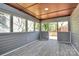 Well-lit screened-in porch with wood-look floors and scenic views of the backyard and deck at 244 N Race St, Statesville, NC 28677