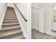 Carpeted staircase leading to the upper level, near a closet with a bi-fold door and a bathroom at 244 N Race St, Statesville, NC 28677