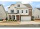Inviting two-story home featuring brick and white siding, a well-manicured lawn, and an attached two-car garage at 3008 Quinebaug Rd, Fort Mill, SC 29715