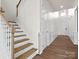 Inviting entryway with a staircase, wooden floors, and detailed trim work, creating a warm and welcoming ambiance at 3008 Quinebaug Rd, Fort Mill, SC 29715