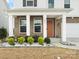 Charming front porch with brick accents, white columns, and a vibrant front door enhancing the curb appeal at 3008 Quinebaug Rd, Fort Mill, SC 29715