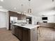 Bright kitchen with a central island, stainless steel appliances, and a view of the adjacent living room with a fireplace at 3008 Quinebaug Rd, Fort Mill, SC 29715
