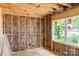 Bedroom under construction with exposed studs, insulation, a window bringing in natural light, and unfinished flooring at 341 Bynum Ave, Rock Hill, SC 29732
