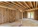 Unfinished living room with exposed beams, studs, insulation and French door showing construction progress at 341 Bynum Ave, Rock Hill, SC 29732