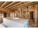 Unfinished living room with exposed beams, studs, and stairwell showing construction progress at 341 Bynum Ave, Rock Hill, SC 29732