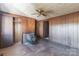 A vintage-style living room with wood-paneled walls, wood-burning stove, and a ceiling fan at 3467 Clearview Ln, Maiden, NC 28650