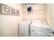 Functional laundry room with white washer and dryer and overhead shelving at 3736 13Th Ne St, Hickory, NC 28601