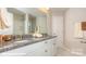 Bright bathroom featuring granite countertop with double sinks, white cabinetry, and tiled floors at 113 Asmodean Ln, Troutman, NC 28166
