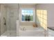 Bright bathroom features a glass shower, soaking tub and large window at 113 Asmodean Ln, Troutman, NC 28166