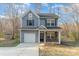 Charming two-story home with gray siding, stone accents, a covered porch, and an attached garage at 3944 Wade E Morgan Rd, Charlotte, NC 28269