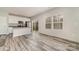 Open concept kitchen and dining area featuring gray wood-look floors, white cabinets and stainless appliances at 3944 Wade E Morgan Rd, Charlotte, NC 28269