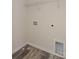 Clean laundry area featuring wood-look floors, utility hookups, and a white wire rack for efficient storage at 3944 Wade E Morgan Rd, Charlotte, NC 28269