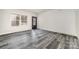 Living room featuring gray wood-look floors, neutral walls, a front door and a large double-hung window at 3944 Wade E Morgan Rd, Charlotte, NC 28269